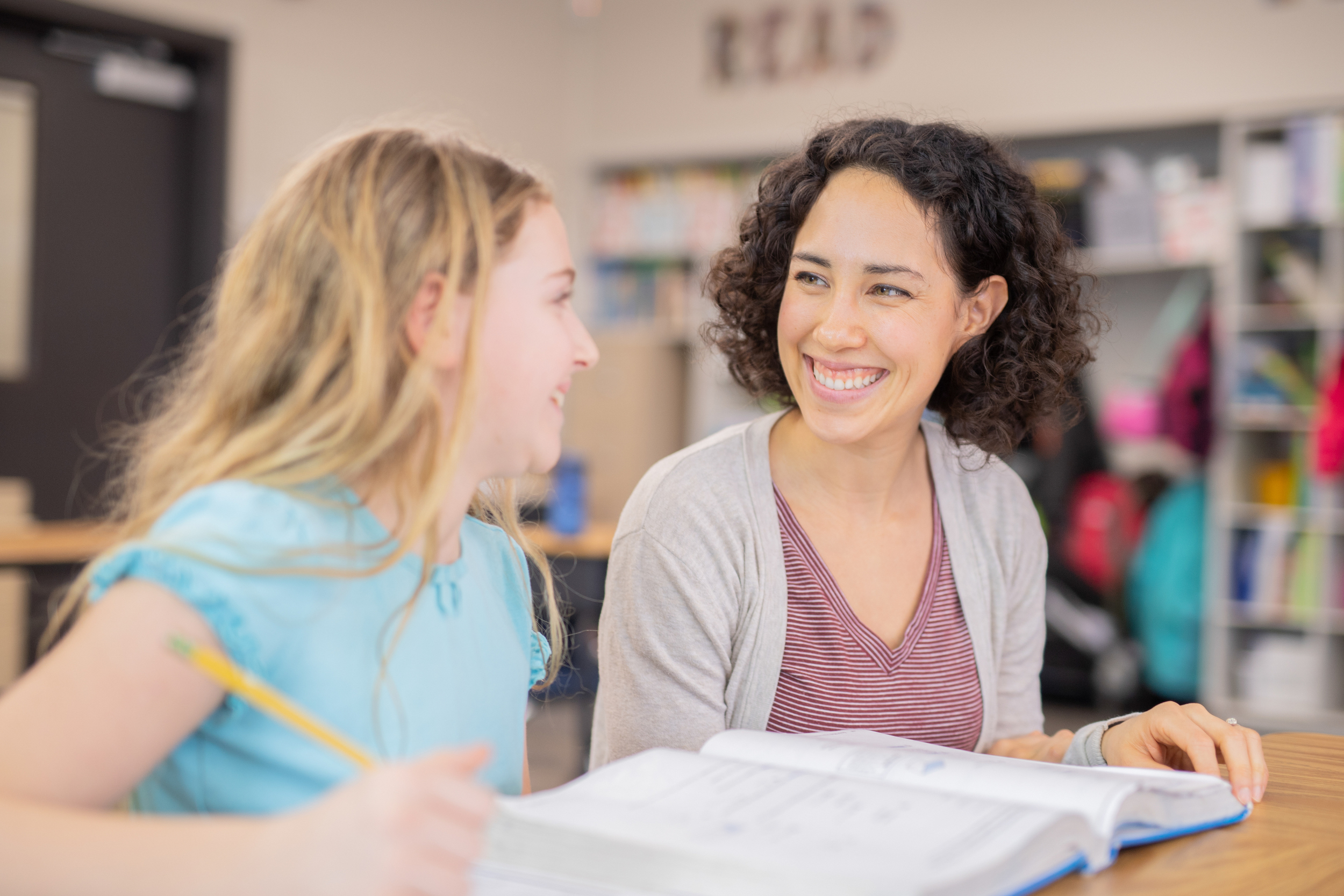 teacher helping elementary student in her classroom