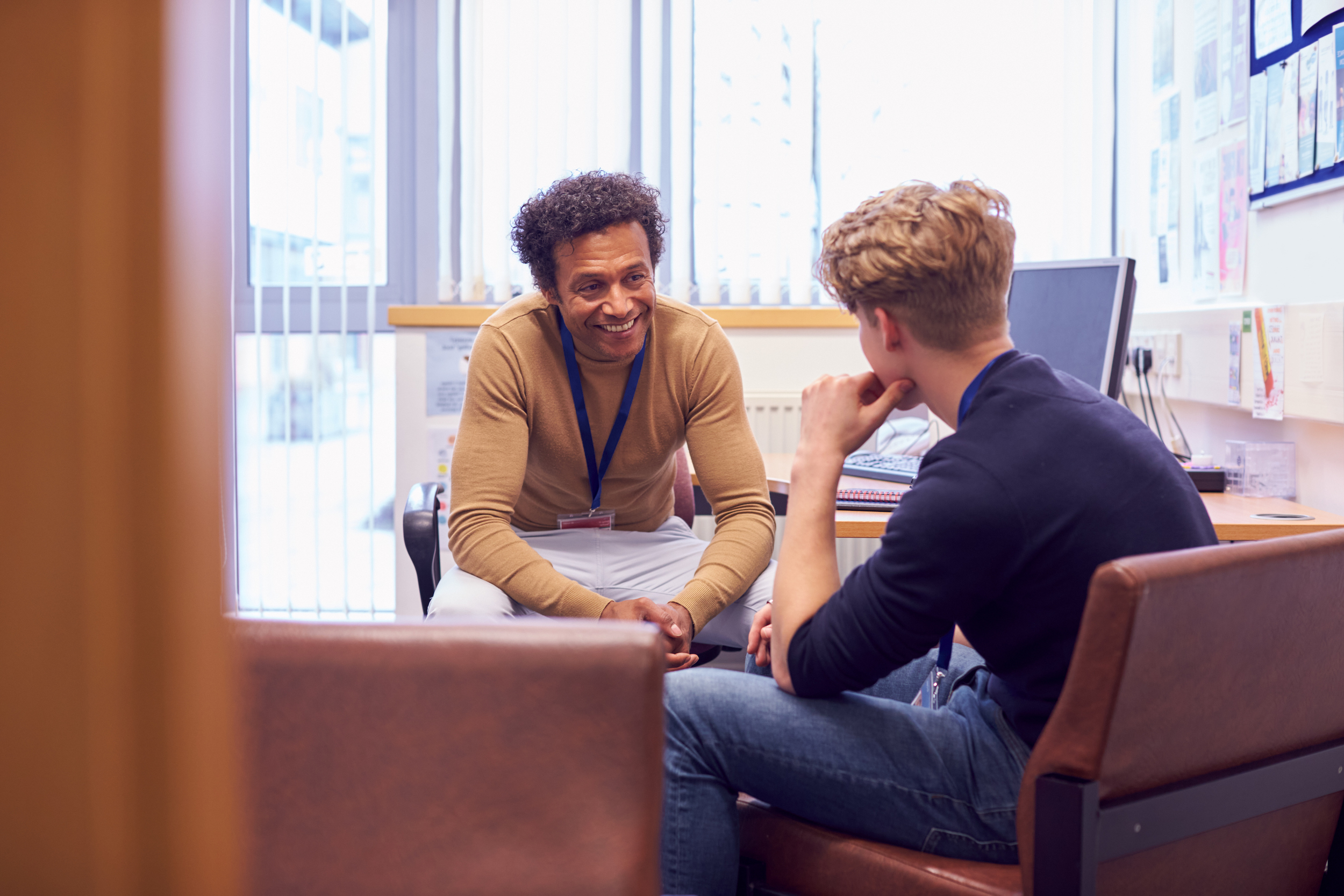 male college student meeting with campus counselor