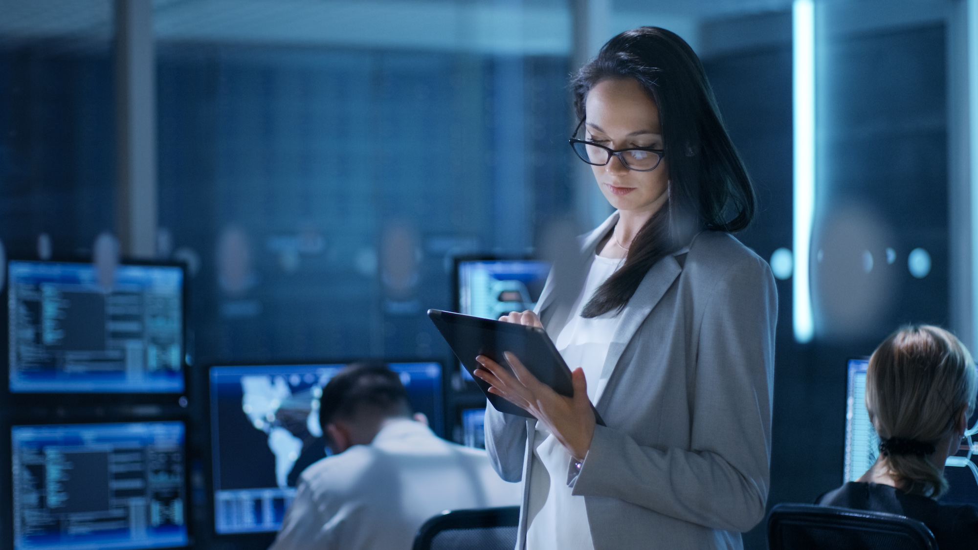 young female engineer uses tablet in system control cente