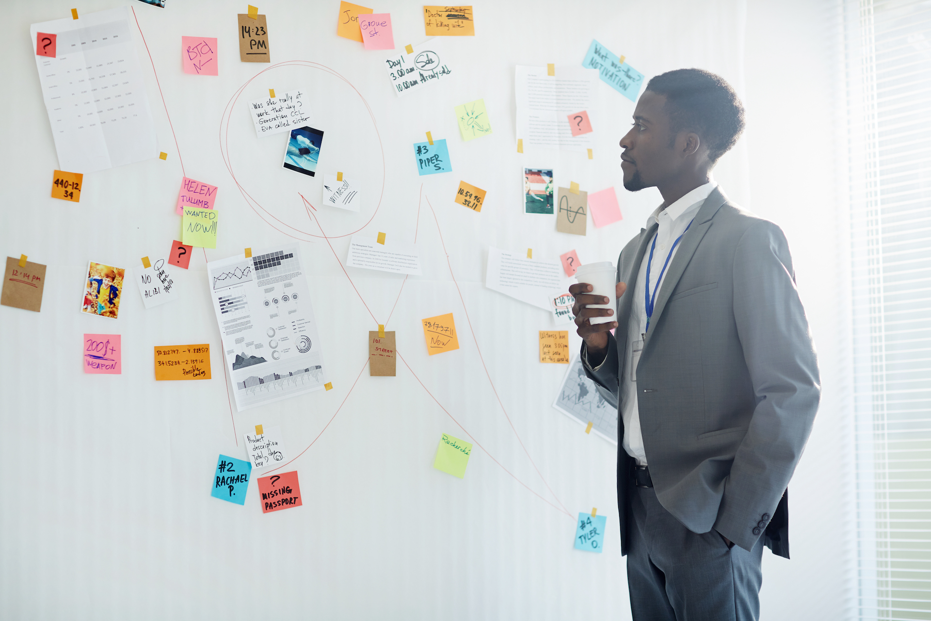 man looking at post-it notes on wall