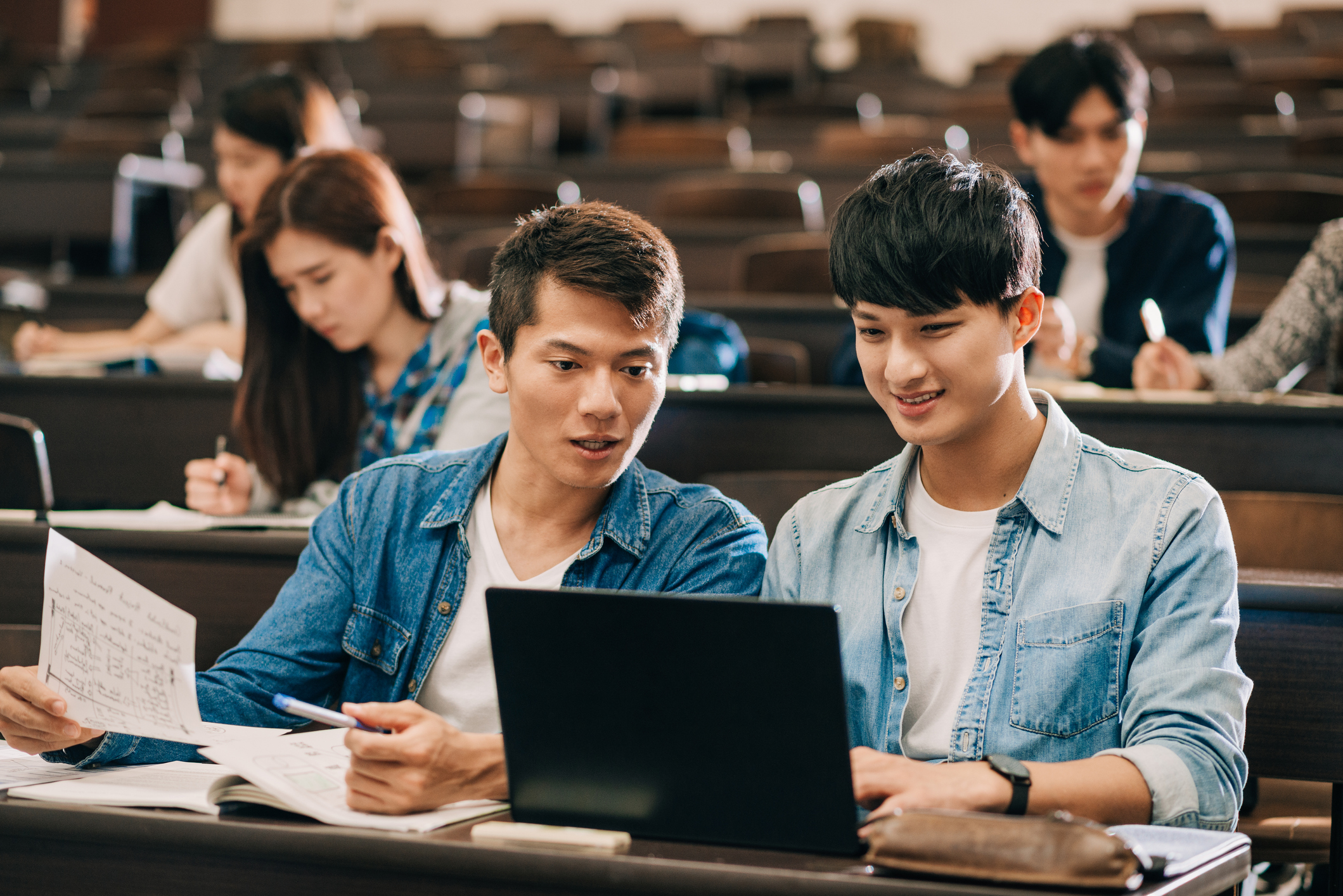 two students looking at a laptop