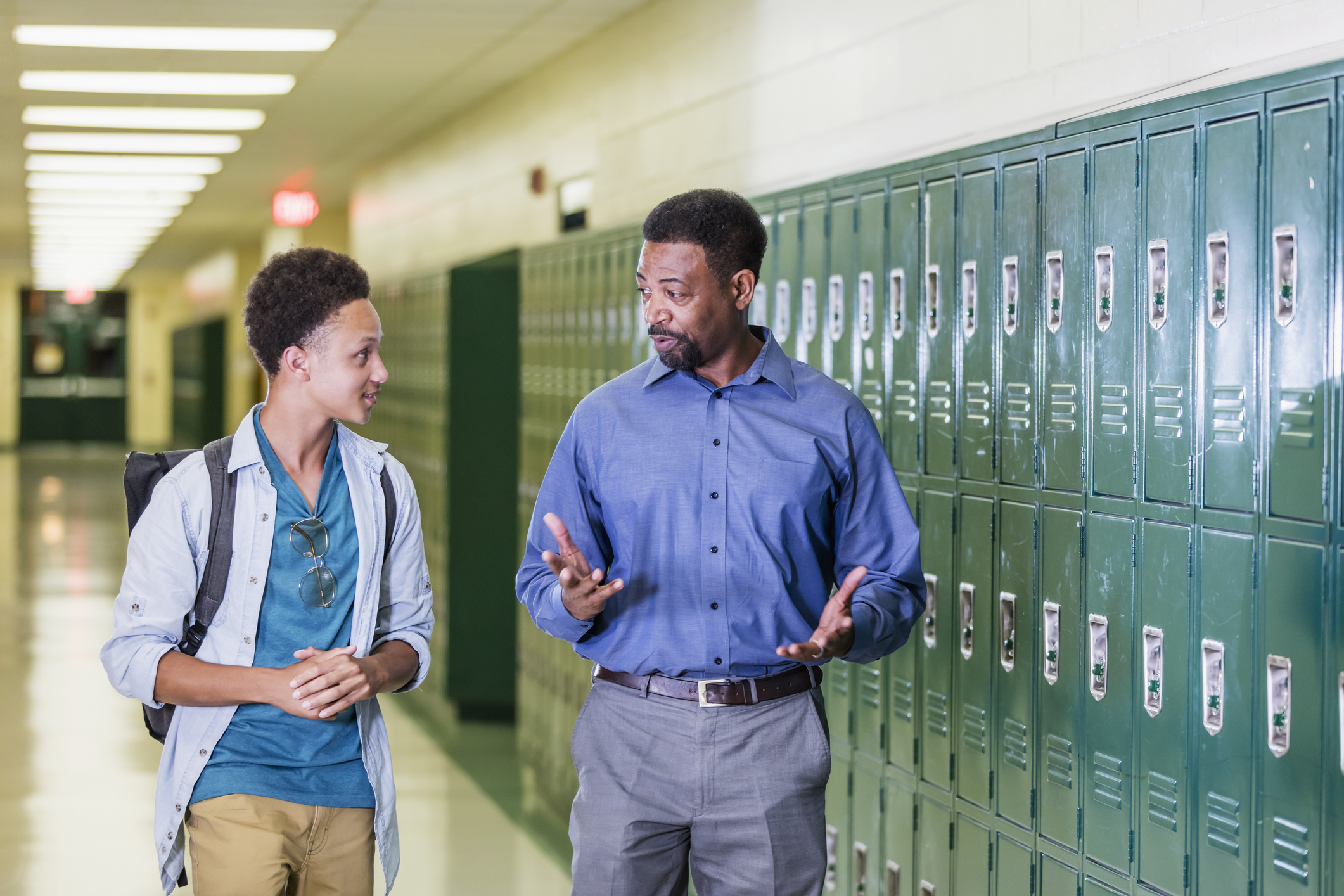 principal talking to student in hallway