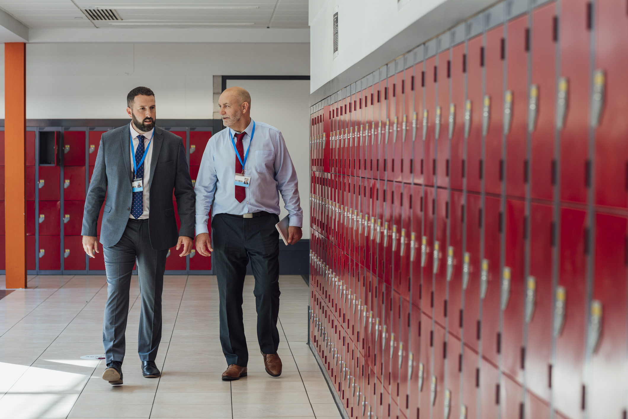 two man walking down a school hallway