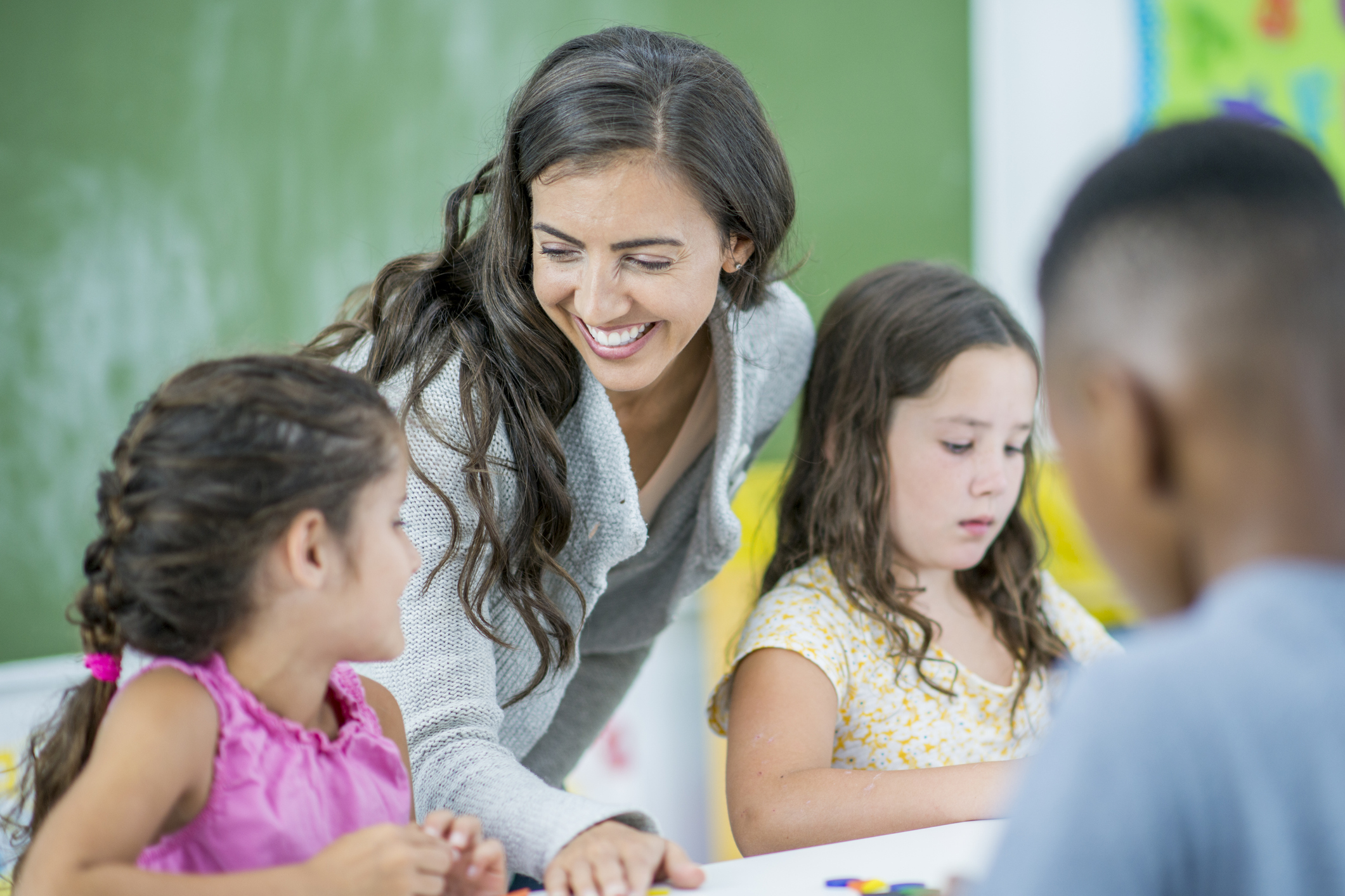 teacher showing students how to solve problem on paper