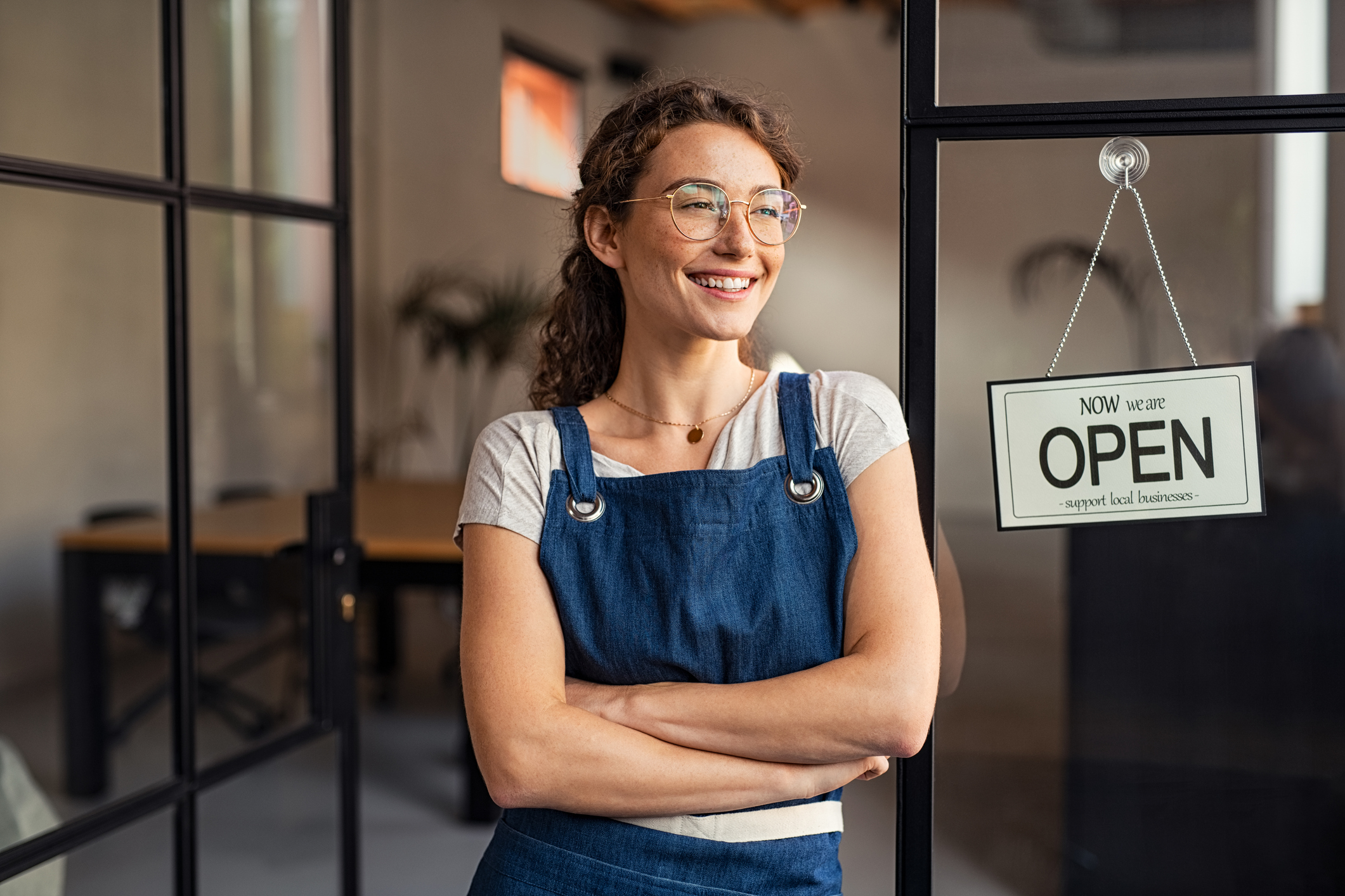 woman with folded arms looking outside of store