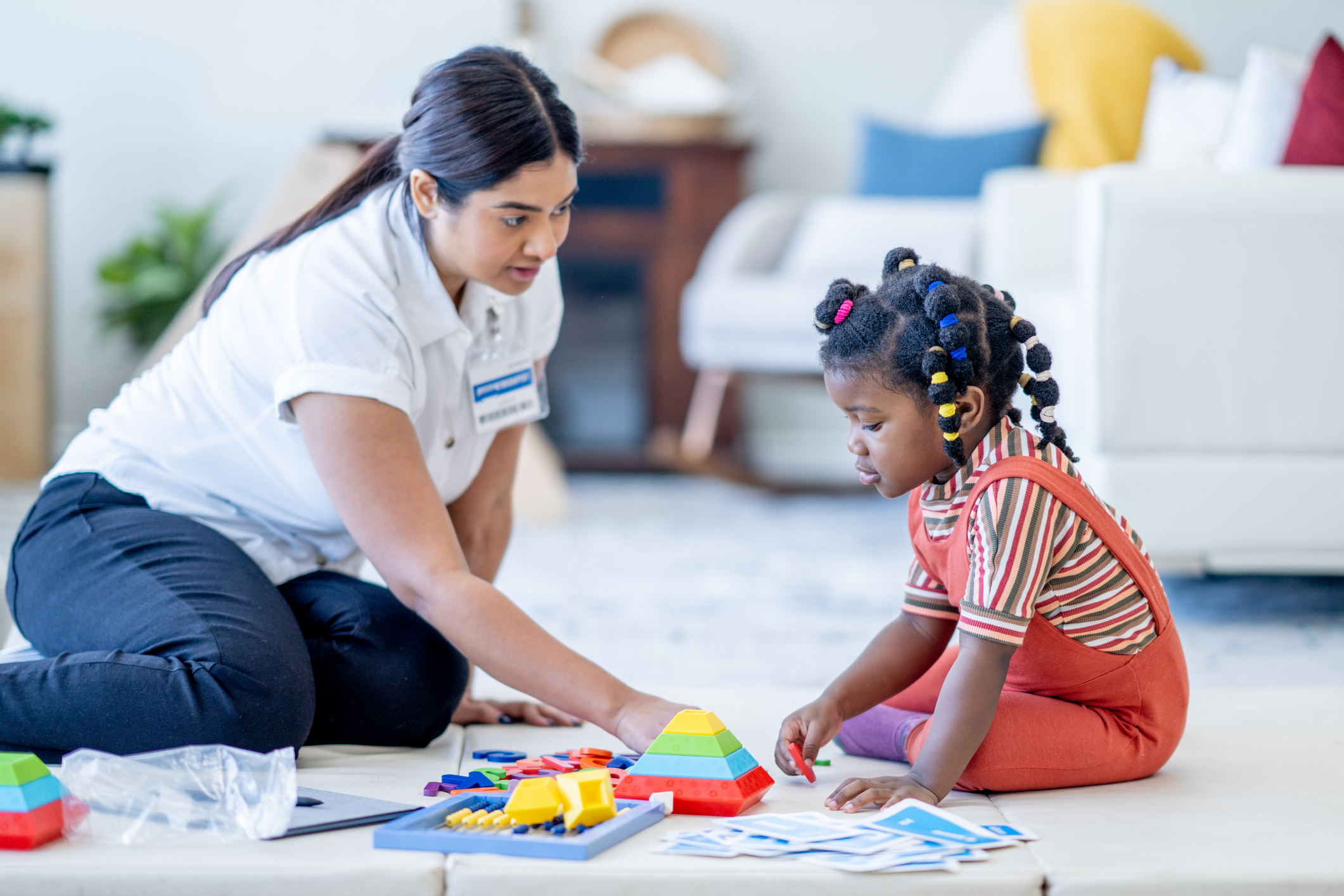 woman helping child with occupational therapy