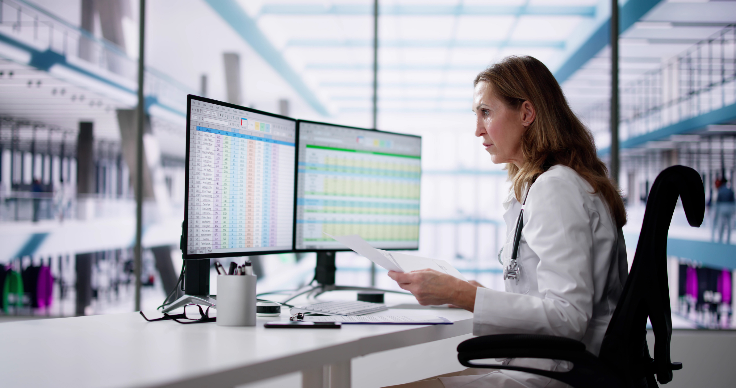 woman looking at data on computer screens